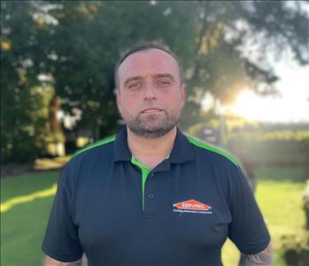 SERVPRO employee in front of outdoor background